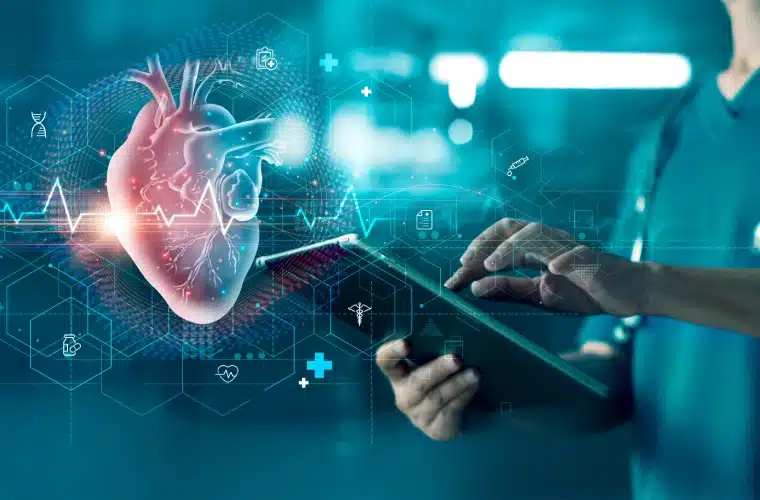 Doctor using a tablet with a holographic heart model and...